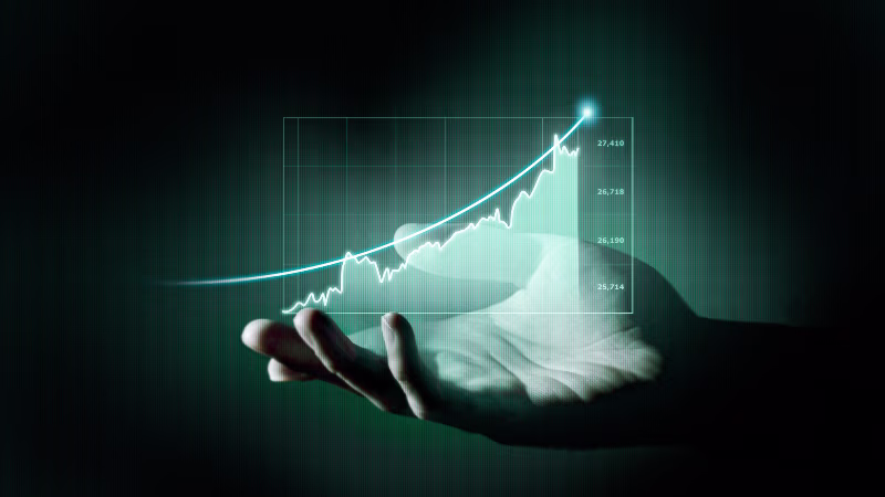 A hand holding a glowing, holographic upward-trending graph in the air, symbolizing growth or success.